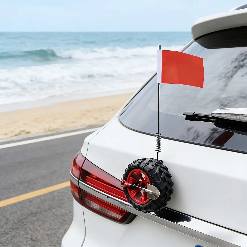 Mini off-road spare tire decoration with shovel and red flag on a car at the beach